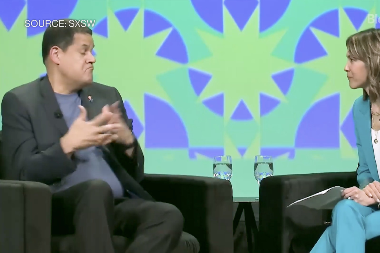 Reggie Fils-Aimé sitting on stage at South by Southwest with journalist Emily Chang.