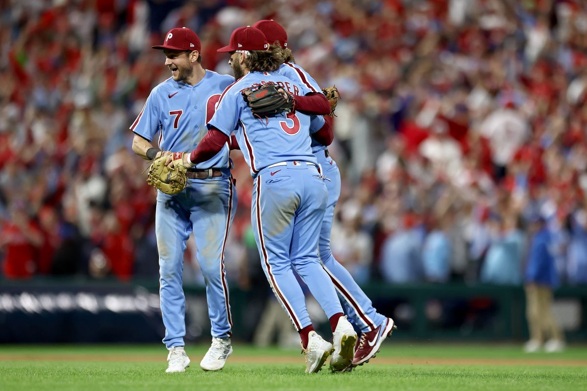 Trea Turner, Alec Bohm, and Bryce Harper of the Philadelphia Phillies celebrate after beating the Atlanta Braves 3-1 in Game Four of the Division Series at Citizens Bank Park on October 12, 2023 in Philadelphia, Pennsylvania.