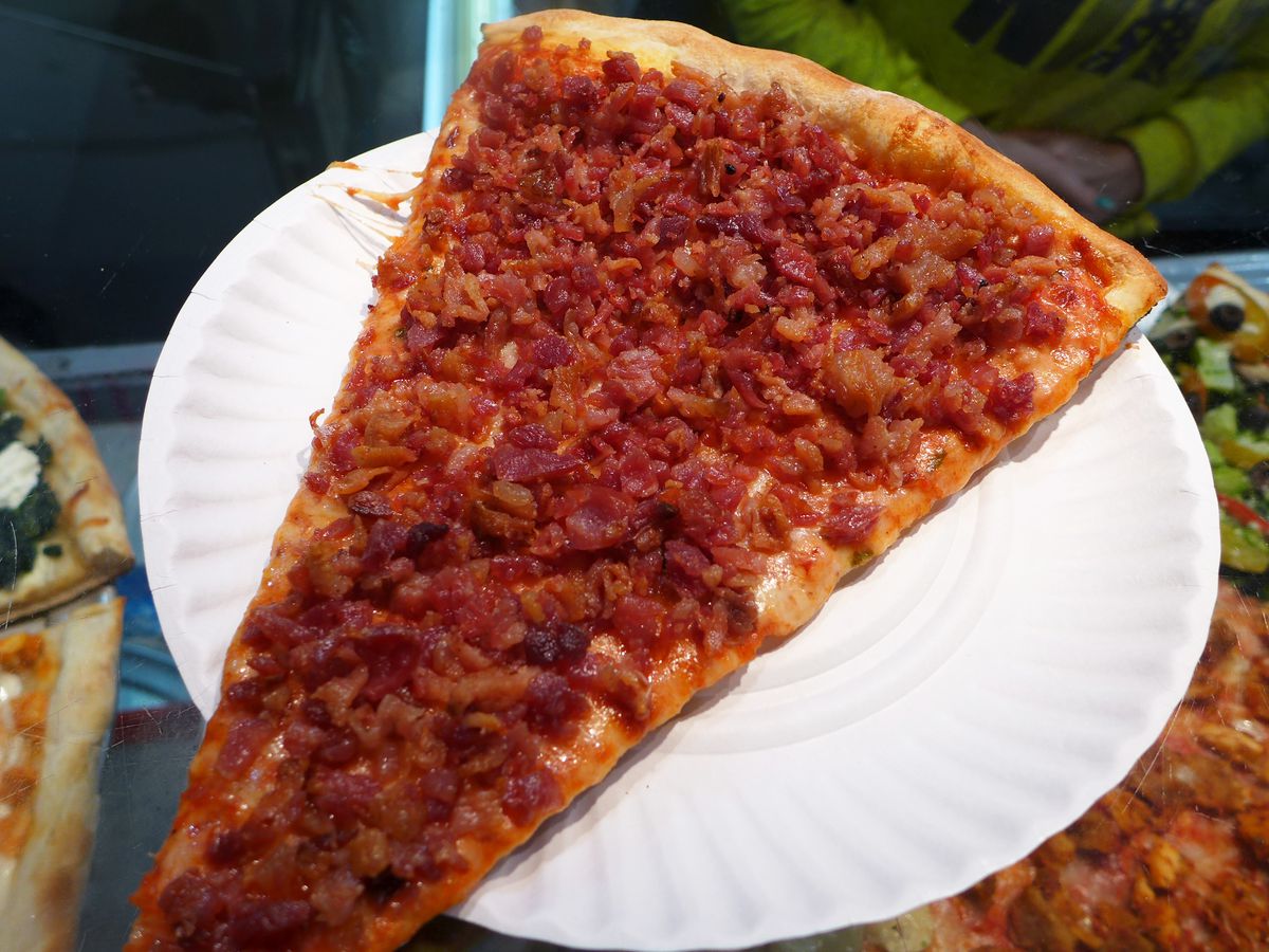 A narrow slice completely obliterated with crumbled bacon.