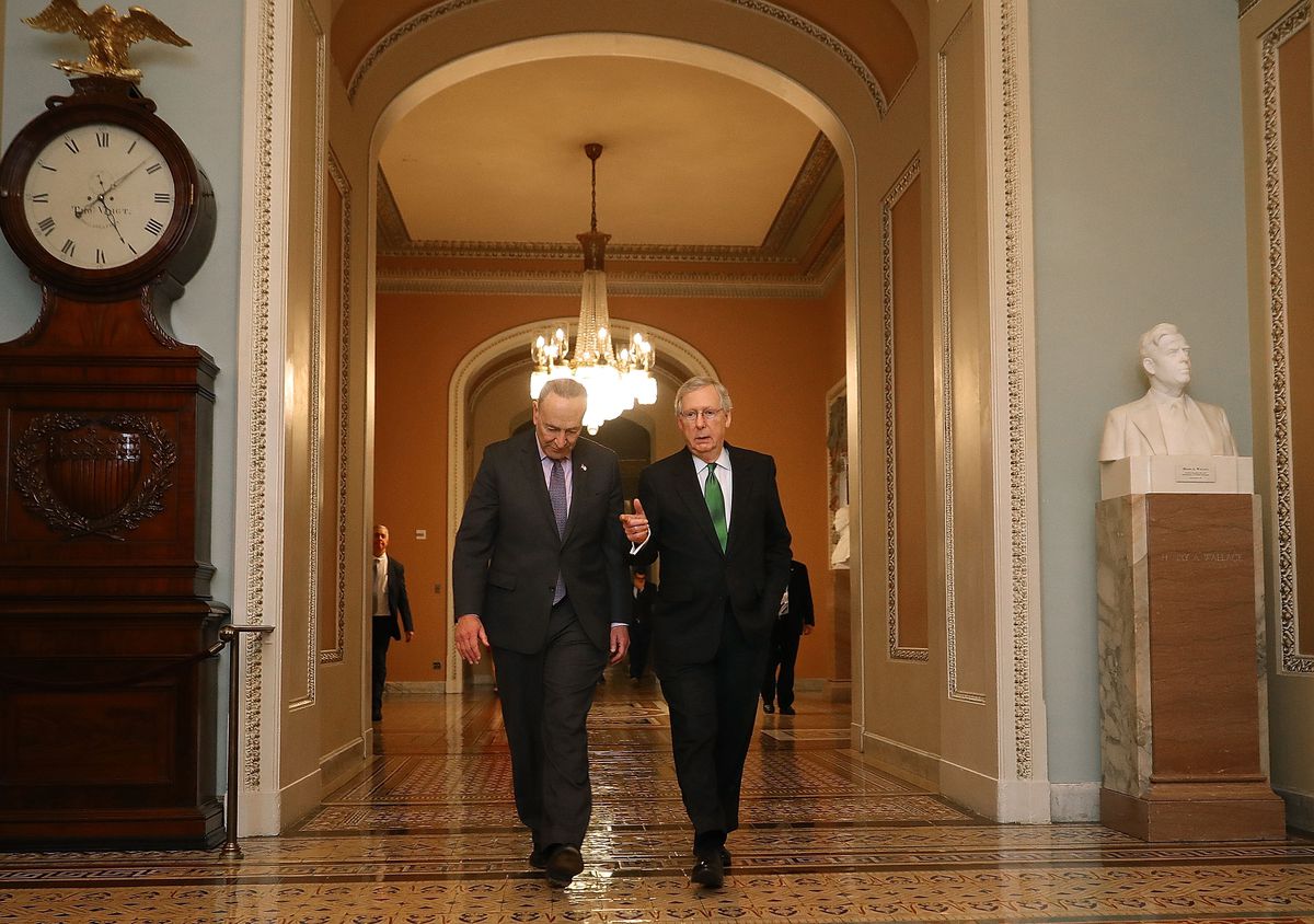 Senate Major Leader Mitch McConnell (R-KY) and Senate Minority Leader Chuck Schumer (D-NY) walk side by side in the halls of US Capitol.