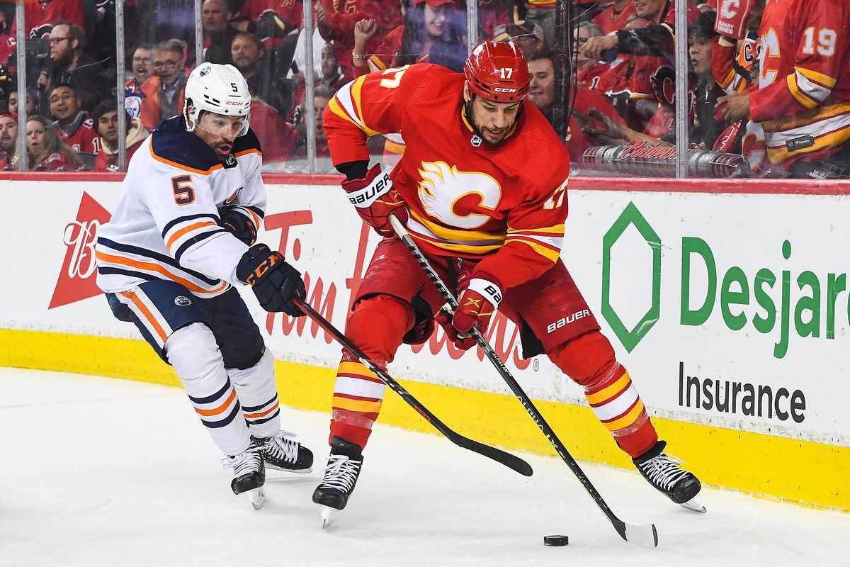 Milan Lucic #17 of the Calgary Flames carries the puck against Cody Ceci #5 of the Edmonton Oilers during the third period of Game Two of the Second Round of the 2022 Stanley Cup Playoffs at Scotiabank Saddledome on May 20, 2022 in Calgary, Alberta, Canada. The Oilers defeated the Flames 5-3.
