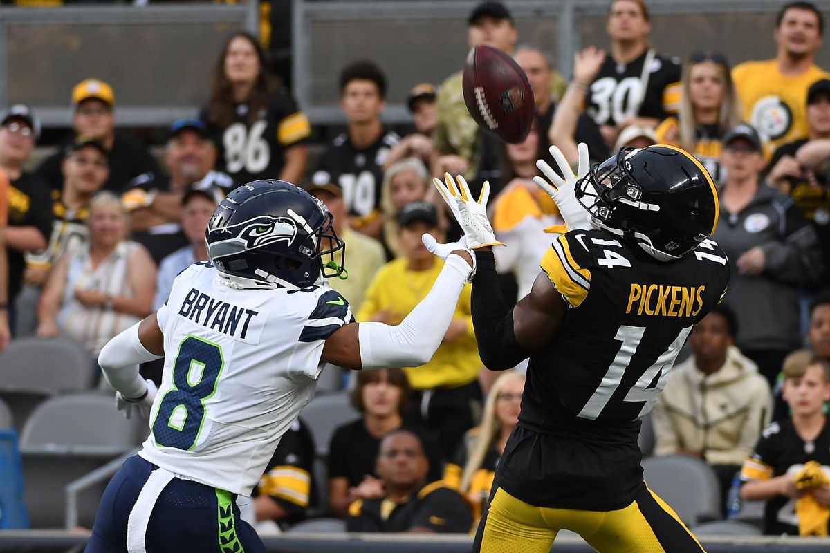 George Pickens #14 of the Pittsburgh Steelers makes a catch for a 26-yard touchdown reception as Coby Bryant #8 of the Seattle Seahawks defends in the first quarter during a preseason game at Acrisure Stadium on August 13, 2022 in Pittsburgh, Pennsylvania.