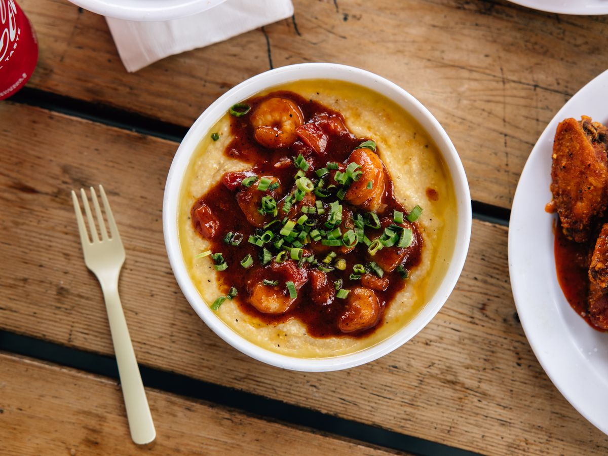 A bowl of tomato-tossed shrimp sits on a bowl of grits at Erica’s Soul Food in Portland, Oregon.