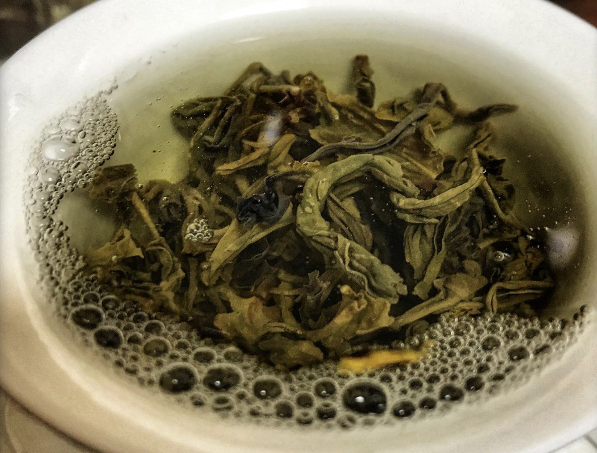 A closeup of Kenyan green tea in a white mug