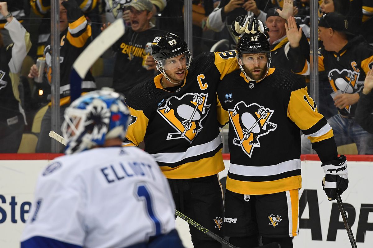 Bryan Rust of the Pittsburgh Penguins celebrates with Sidney Crosby after scoring a goal in the third period during the game against the Tampa Bay Lightning at PPG PAINTS Arena on October 15, 2022 in Pittsburgh, Pennsylvania.