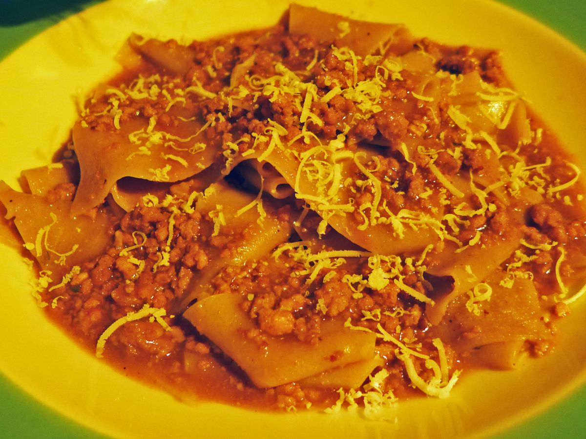 Wide noodles with crumbly sauce and a bit of grated cheese on top.