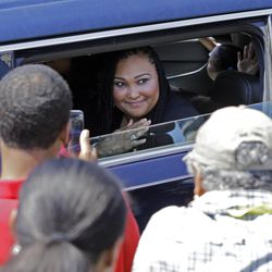 Muhammad Ali's daughter Maryum waves to the crowd lining the street as the funeral procession for her father passes in front of his boyhood home Friday, June 10, 2016, in Louisville, Ky. 