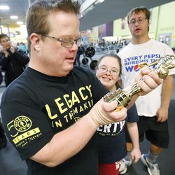 James Fitzgerald looks at an award he received from Gold's Gym in Ogden on Monday, Dec. 5, 2016. Fitzgerald, who has Down syndrome, teaches a fitness class with his brother, Evan, specifically for people with disabilities.