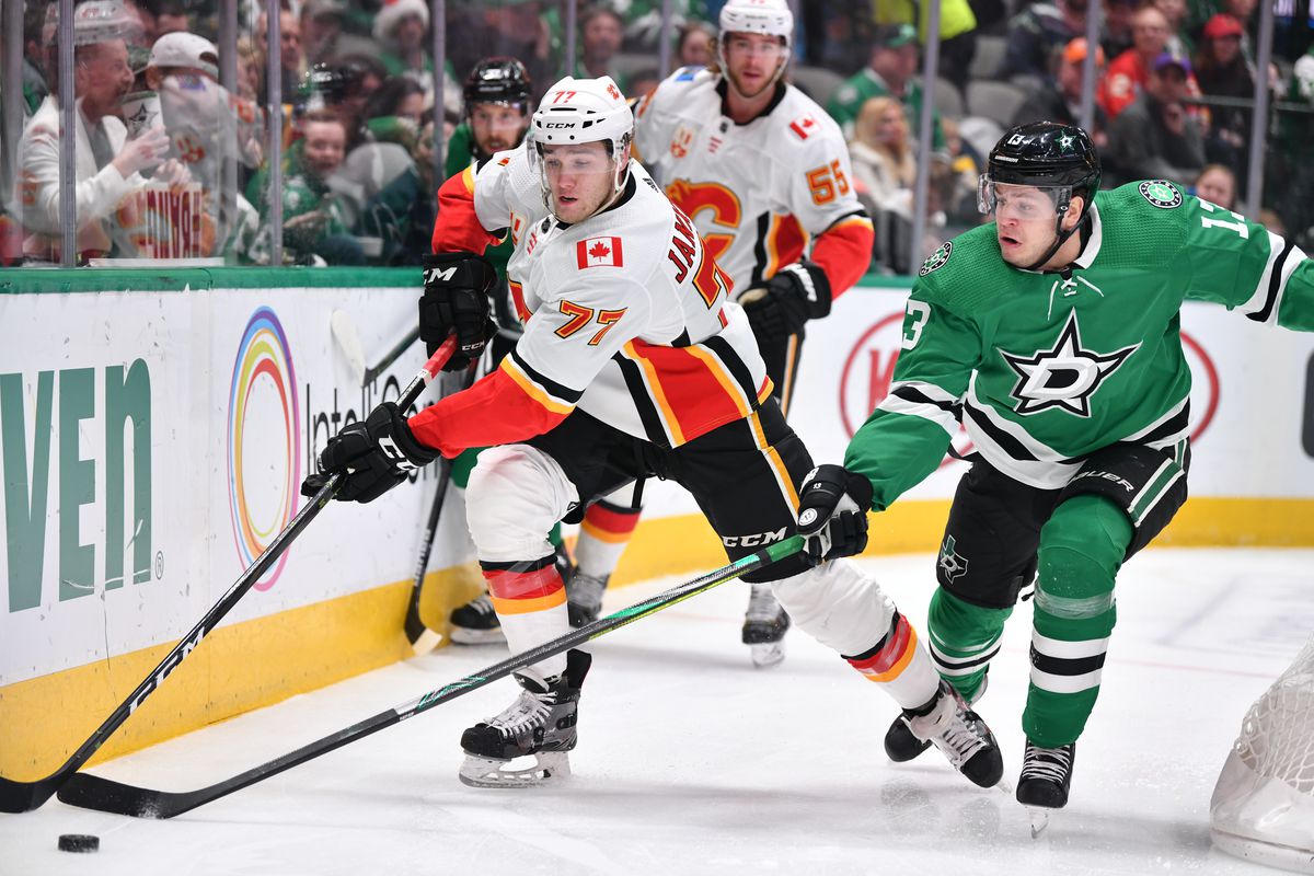 Mark Jankowski of the Calgary Flames tries to keep the puck away against Mattias Janmark of the Dallas Stars at the American Airlines Center on December 22, 2019 in Dallas, Texas.