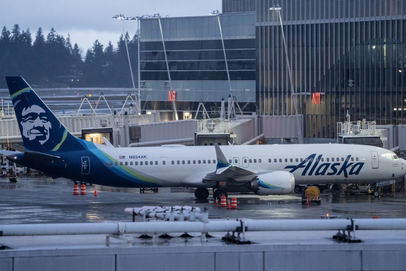 A picture of a Boeing 737 Max 9 plane sitting at a gate at an airport in Seattle.
