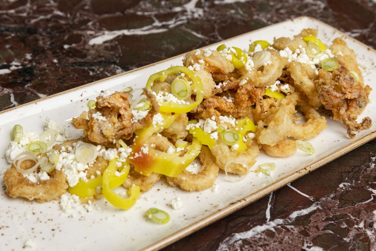 A plate of fried calamari and shrimp with banana peppers.
