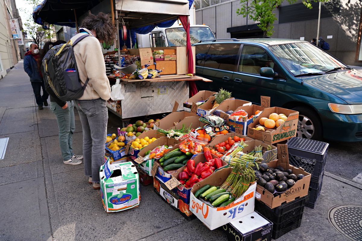 A man shops for produce at a sidewalk stand during the coronavirus pandemic on April 12, 2020 in New York City.