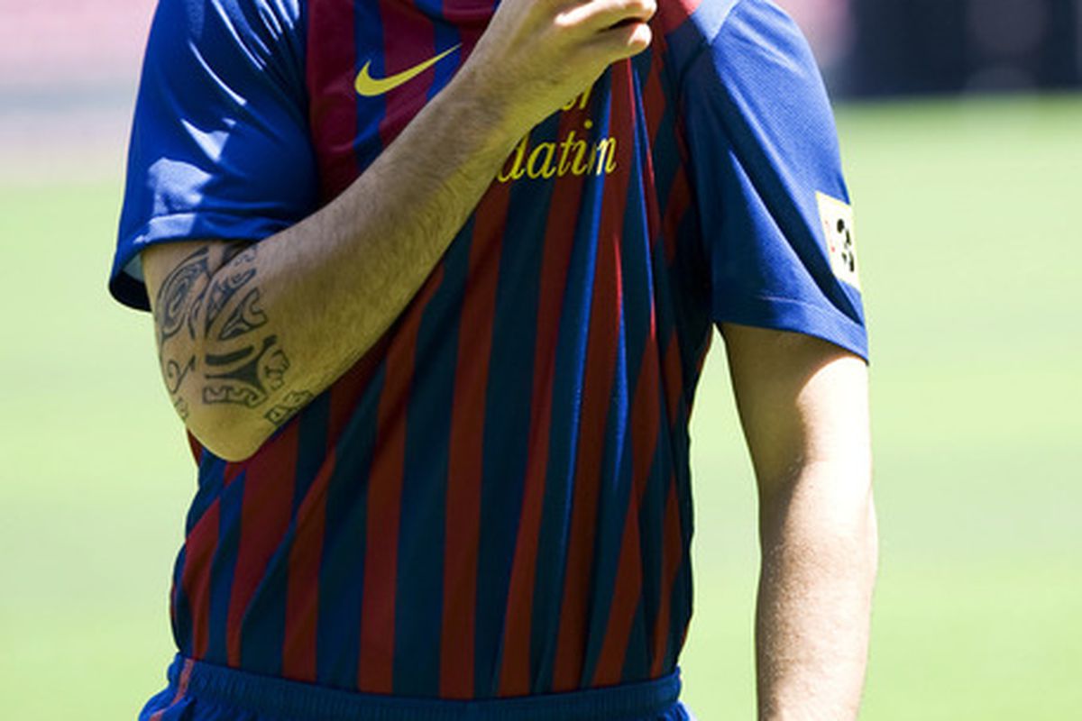 BARCELONA, SPAIN - AUGUST 15:  Cesc Fabregas kisses the t-shirt badge during his presentation as the new signing for FC Barcelona at Camp Nou sports complex on August 15, 2011 in Barcelona, Spain.  (Photo by David Ramos/Getty Images)