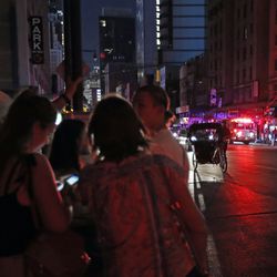 People gather in midtown Manhattan during a widespread power outage, Saturday, July 13, 2019, in New York. Authorities were scrambling to restore electricity to Manhattan following a power outage that knocked out Times Square's towering electronic screens, darkened marquees in the theater district and left businesses without electricity, elevators stuck and subway cars stalled. (AP Photo/Michael Owens)