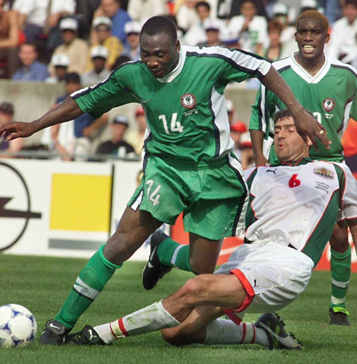 Nigerian forward Daniel Amokachi (L) is challenged