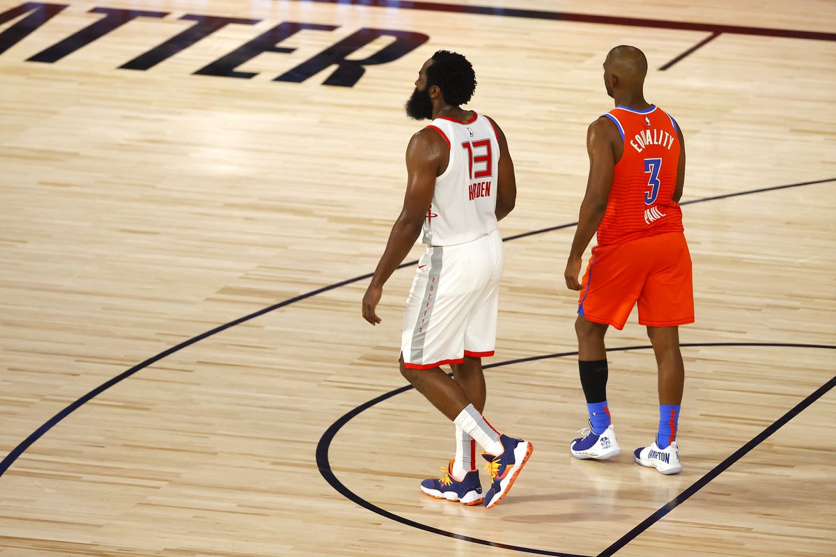 James Harden  of the Houston Rockets and Chris Paul of the Oklahoma City Thunder stand on the court together during the second quarter in Game Three of the Western Conference First Round during the 2020 NBA Playoffs at The Field House at ESPN Wide World Of Sports Complex on August 22, 2020 in Lake Buena Vista, Florida.
