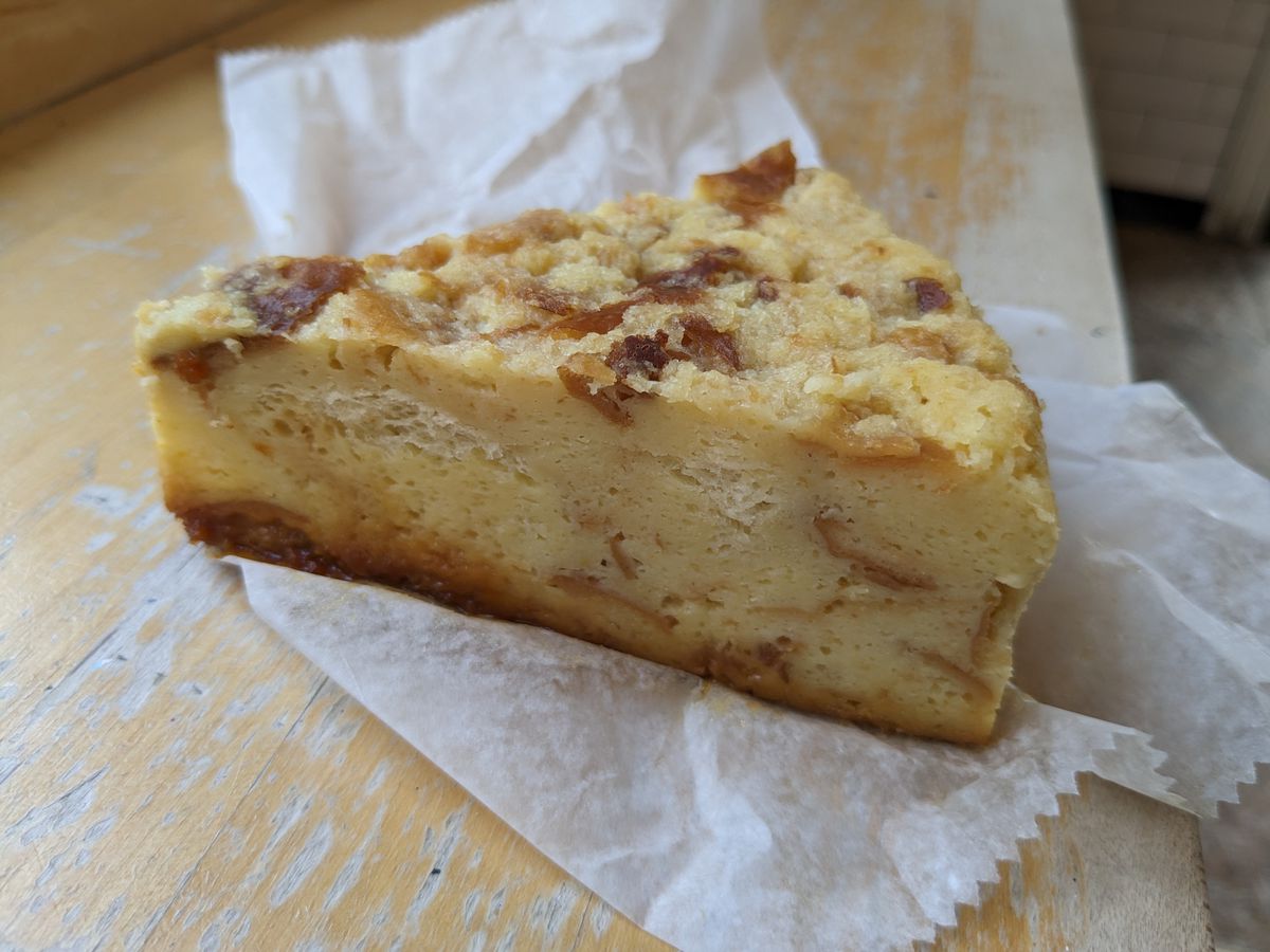 A pie shaped wedge of sticky looking bread pudding.