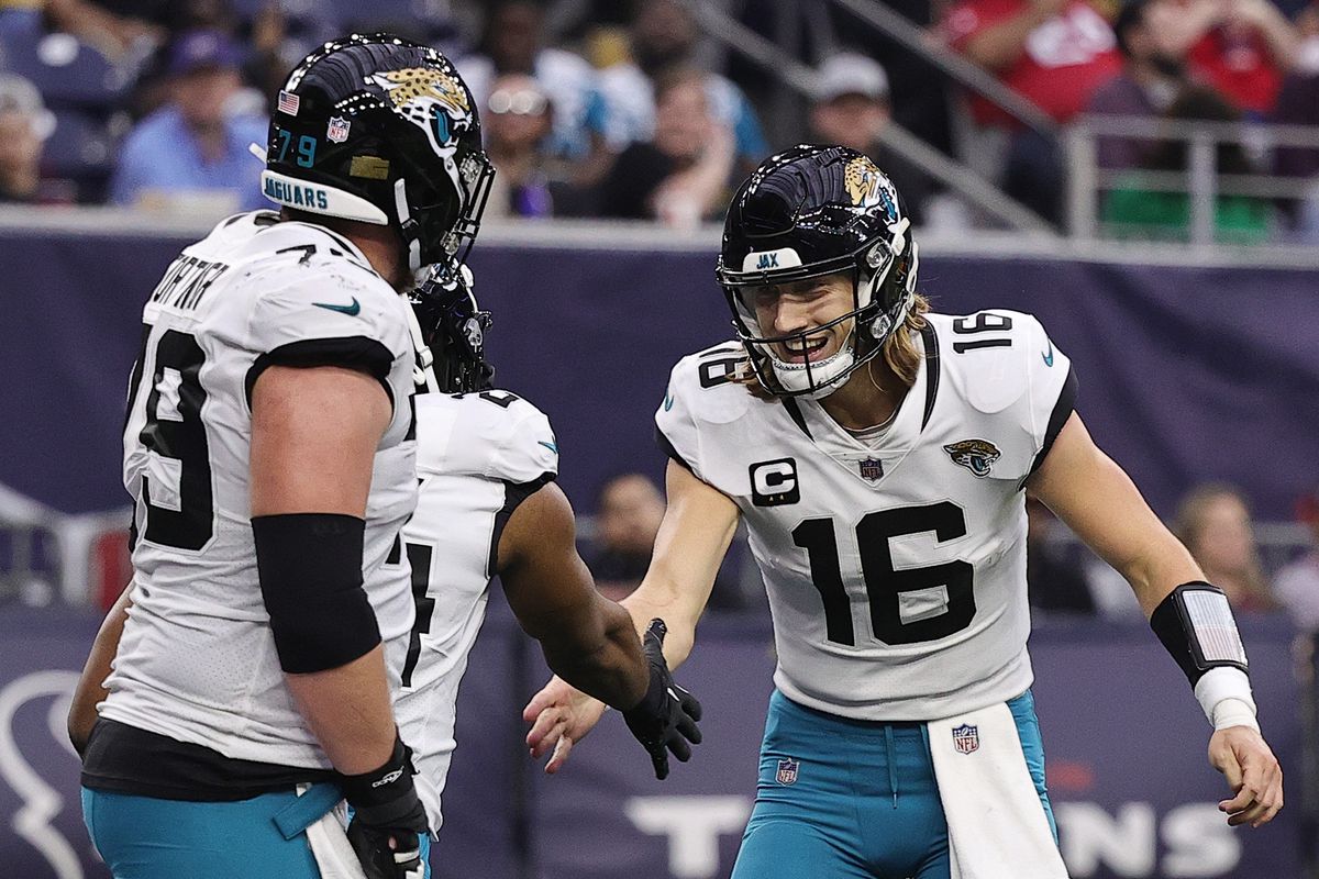 Trevor Lawrence #16 of the Jacksonville Jaguars celebrates with Snoop Conner #24 of the Jacksonville Jaguars after a touchdown during the third quarter at NRG Stadium on January 01, 2023 in Houston, Texas.