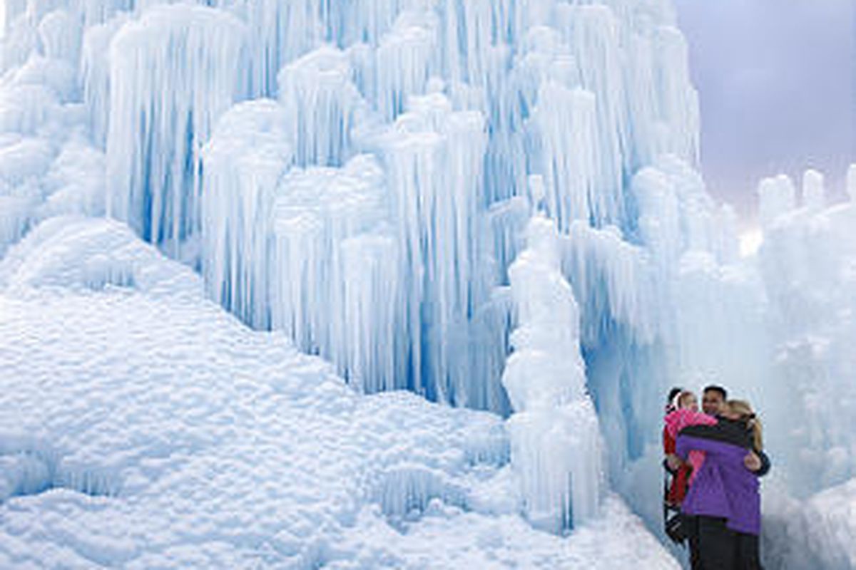 Amy and Joe Barrion, with their children Elijah and  Isabella, walk through an ice castle Thursday, created by Brent Christensen at Zermatt Resort in Midway, near the resort's geothermal hot springs. Christensen has created 18 of the structures, which are