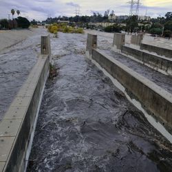 Rushing rainwater fills the Los Angeles river near downtown Los Angeles on Tuesday, Dec. 9, 2018. The first significant storm of the season walloped much of California with damaging winds and thunderstorms. (AP Photo/Richard Vogel)