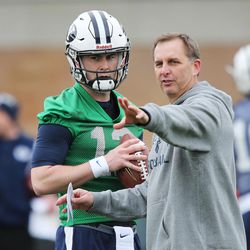 Brigham Young Cougars  coach Ty Detmer  talks with Brigham Young Cougars quarterback Tanner Mangum (12)  during practice in Provo Tuesday, March 1, 2016.