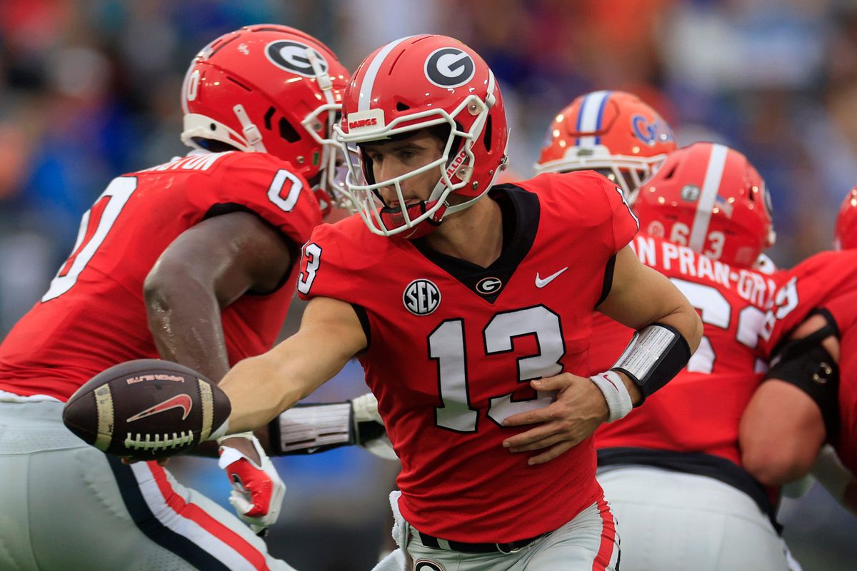 Georgia Bulldogs quarterback Stetson Bennett hands off during the first quarter of an NCAA football game Saturday, Oct. 29, 2022 at TIAA Bank Field in Jacksonville.