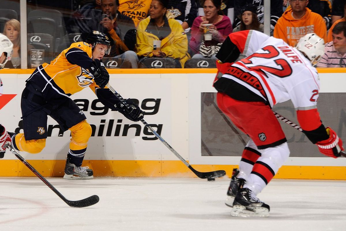 NASHVILLE, TN - OCTOBER 01:  Nick Spaling #13 of the Nashville Predators passes the puck past Zac Dalpe #22 of the Carolina Hurricanes at the Bridgestone Arena on October 1, 2011 in Nashville, Tennessee.  (Photo by Frederick Breedon/Getty Images)