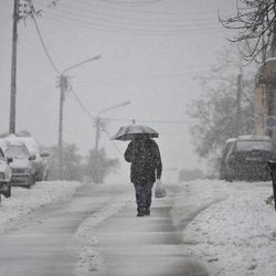 A Palestinian man protects himself from snowfall in the West Bank City of Nablus, Friday, Feb. 20, 2015. A heavy winter storm hit parts of the Middle East on Friday, shutting down roads leading in and out of Jerusalem and sprinkling areas of Israel's desert with a rare layer of white. Snow also fell in parts of the West Bank, Lebanon, Jordan and Syria as a cold front swept through the region. 