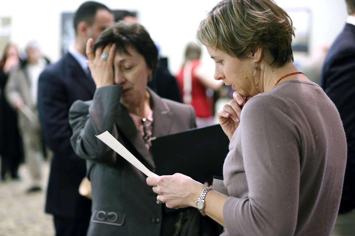 In this Monday, Feb. 25, 2013 photo, Ann Oganesian, left, of Newton, Mass., pauses as she speaks with a State Department employee about job opportunities with the federal government during  a job fair in Boston. 