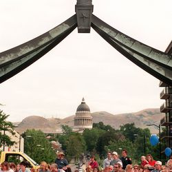 People watch the Days of ’47 Parade at State Street and South Temple with the Eagle Gate and the Utah Capitol behind them on July 24, 1998.