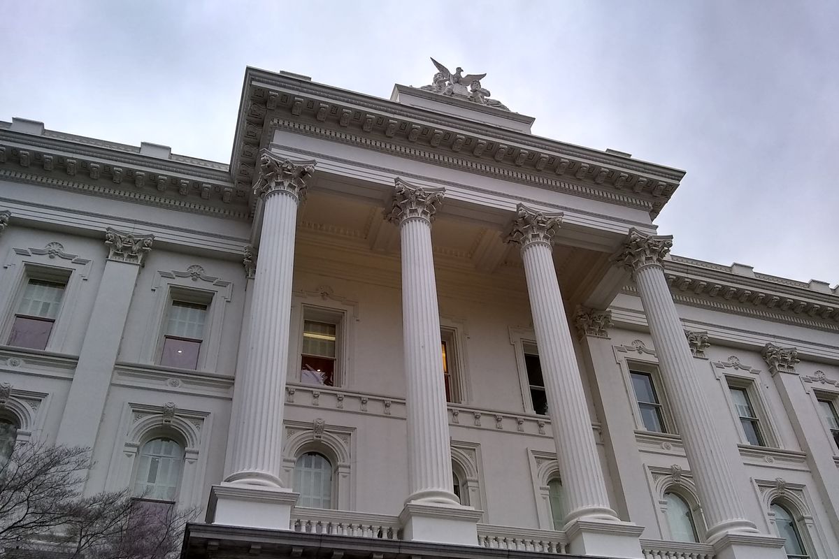 A low-angle shot of the columned facade of the State Capitol building in Sacramento.
