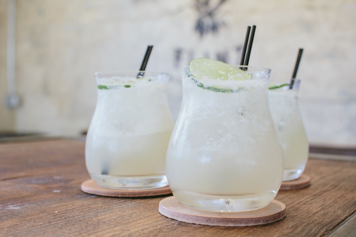 three glasses of frozen margaritas with lime.