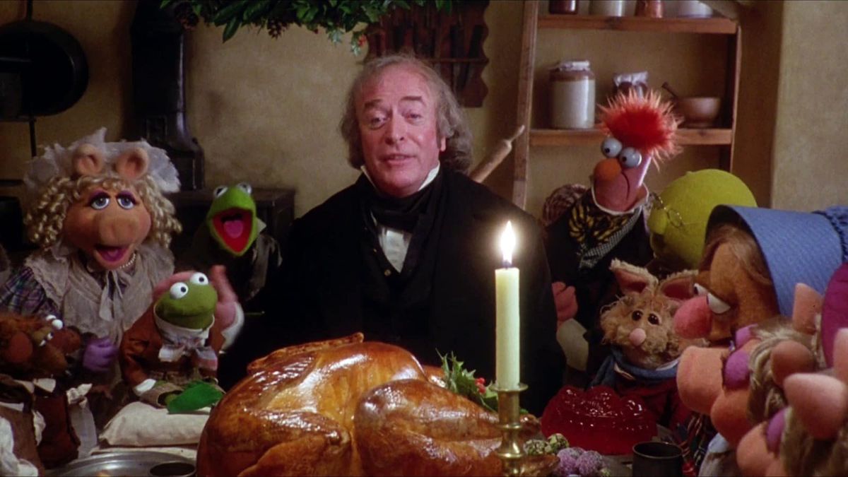 The Muppet Christmas Carol, dengan Michael Caine di makan malam Natal yang besar, dikelilingi oleh Muppets