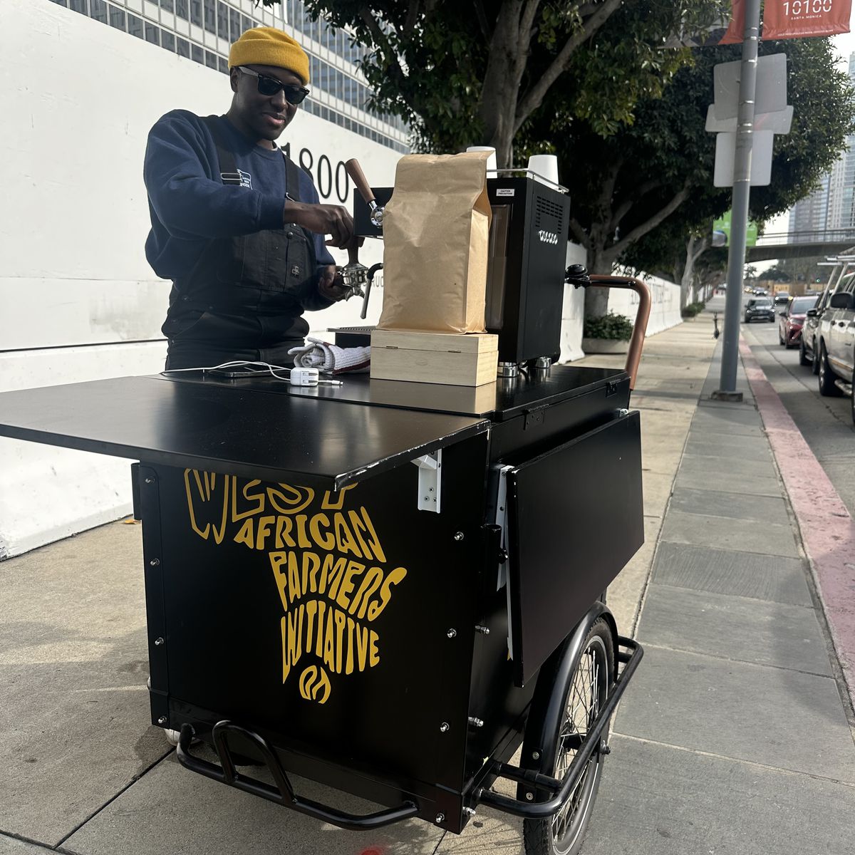 A man leans against a coffee bike named WAFI Coffee in Los Angeles.