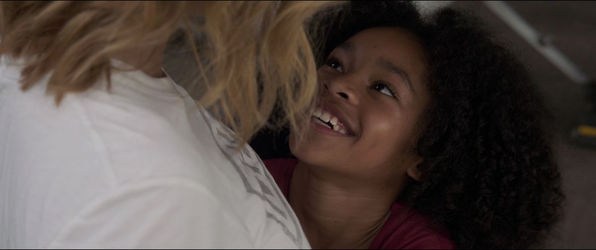 A young Monica Rambeau smiles up at Carol Danvers in Captain Marvel.