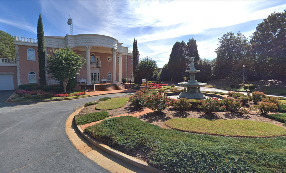 A view from the driveway, which runs around a fountain with a statue on top. 