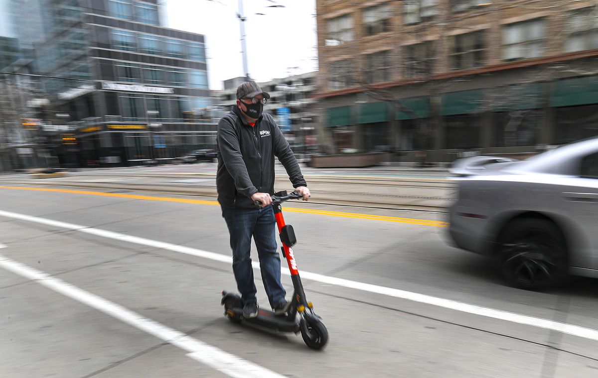 Devin Youngblood, responsable de l'équipe du matin pour Spin, conduit l'un des scooters électriques de la société sur Main Street à Salt Lake City le mardi 9 mars 2021. Spin a développé une nouvelle technologie qui donnera des informations aux motocyclistes leur permettant de suivre les règles de la ville lorsque monter les e-scooters.