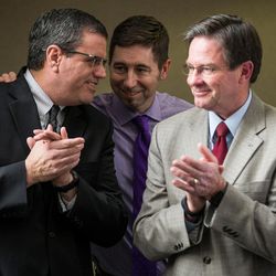 Mike Todd, CFO and associate publisher of the Deseret News, left, is congratulated by Chuck Wing, managing editor for cross platform news for KSL Broadcasting and the Deseret News, center, and Roland Radack, vice president of community relations for Deseret Management Corp., after a staff meeting at the newspaper's offices in Salt Lake City on Wednesday, Dec. 21, 2016.