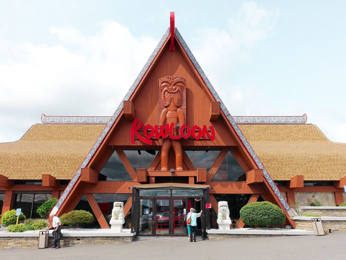 Exterior view of a restaurant with a large A-frame entrance and red signage