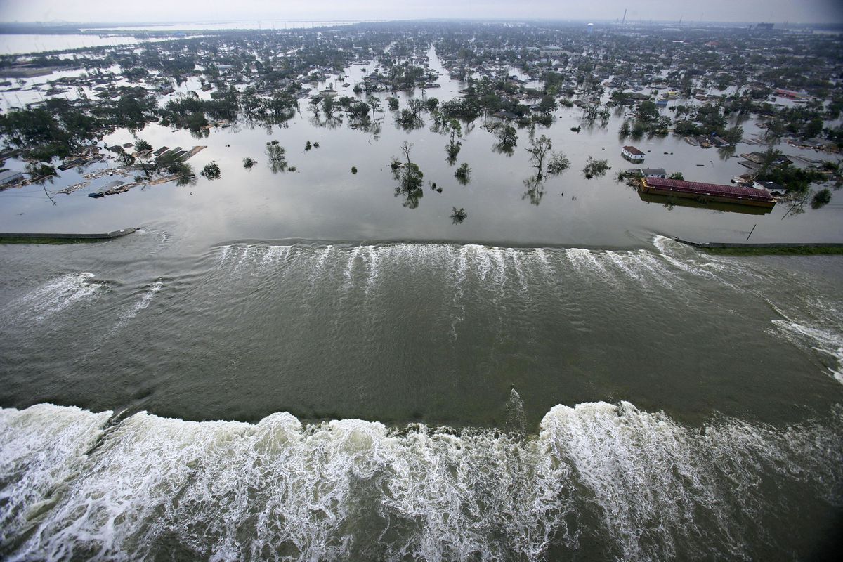 Water spills over a levee toward New Orleans during Hurricane Katrina.
