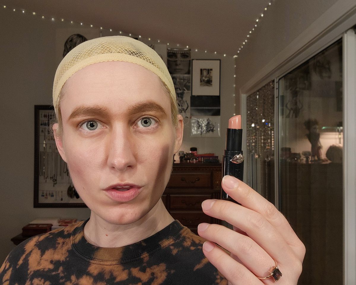 The author using a matte lipstick to apply highlighter shade