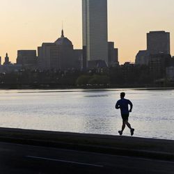 A solitary runner heads down the banks of the Charles River in Cambridge, Mass., in front of the Boston skyline, at dawn the morning after explosions killed three and injured more than 140 at the Boston Marathon, Tuesday, April 16, 2013. The bombs that blew up seconds apart at the finish line of one of the world's most storied races left the streets spattered with blood and glass, and gaping questions of who chose to attack at the Boston Marathon and why. 