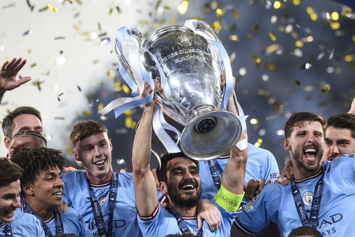 Ilkay Gundogan (C) of Manchester City FC lifts the trophy as...