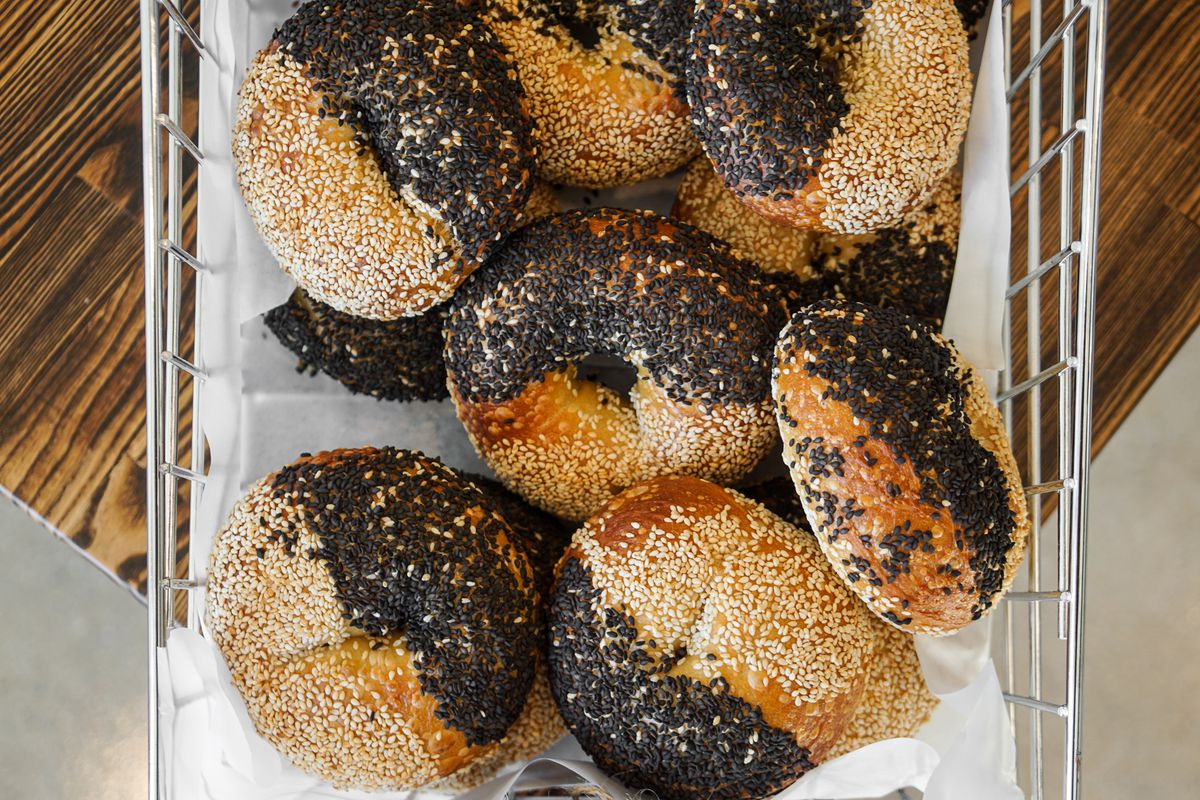 Sesame bagels with black and white sesame seeds in a basket.