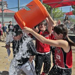 Bear River coach Calvin Bingham was doused by Marlee Mecham (31), center, and Katie Haramtoto (32) after Bear River won the 2009 3A Utah high school softball championship as seen in this May 16, 2009file photo.
