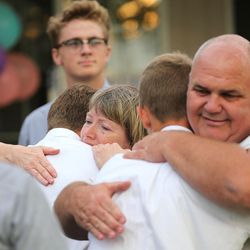 Doug and Tracy Julian hug members of the Salem Hills High School football team after they sang "Nearer, My God to Thee" on the front lawn of their Woodland Hills home on Sunday, Aug. 6, 2017. The couple's son, also named Doug, died Saturday of apparent altitude sickness while on a Boy Scout outing in the High Uintas. He was also a member of the football team.