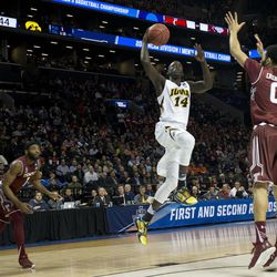 Iowa guard Peter Jok (14) goes to the basket past Temple forward Obi Enechionyia (0) and guard Josh Brown (1) during the second half of a first round men's college basketball game in the NCAA Tournament on March 18 in New York. Iowa won 72-20 in overtime. (AP Photo/Mary Altaffer)