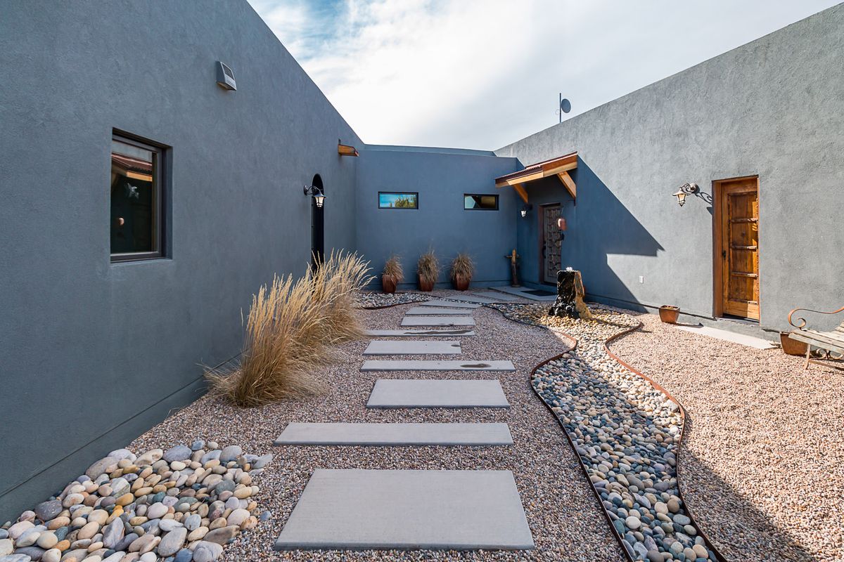 The courtyard of a southwestern home with a rock path