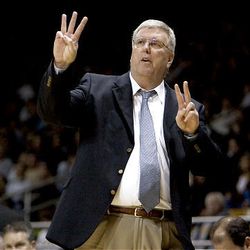 Utah State head coach Stew Morrill, center, signals a play to his offense during the second half of an NCAA college basketball game against Idaho.