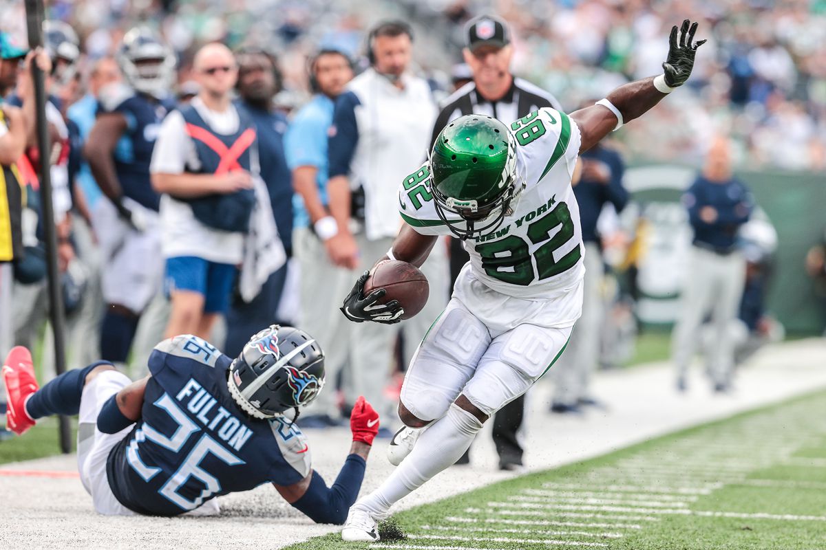 New York Jets wide receiver Jamison Crowder (82) fights to stay in bounds during a reception as Tennessee Titans cornerback Kristian Fulton (26) tackles at MetLife Stadium.